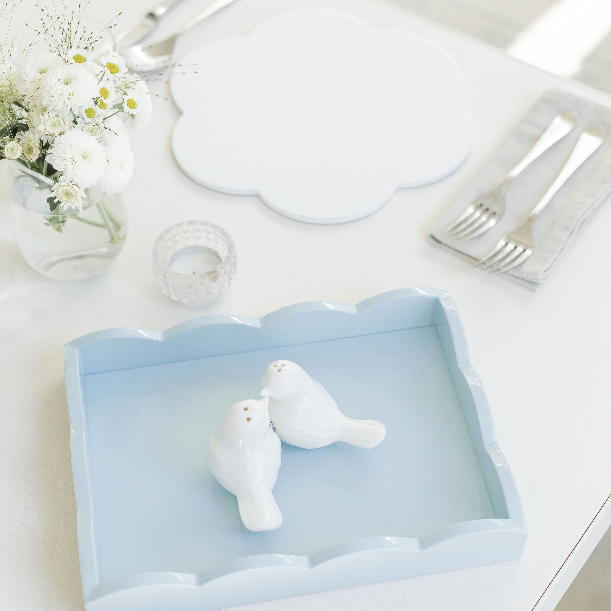 Small, pale blue scalloped edge tray displaying trinkets