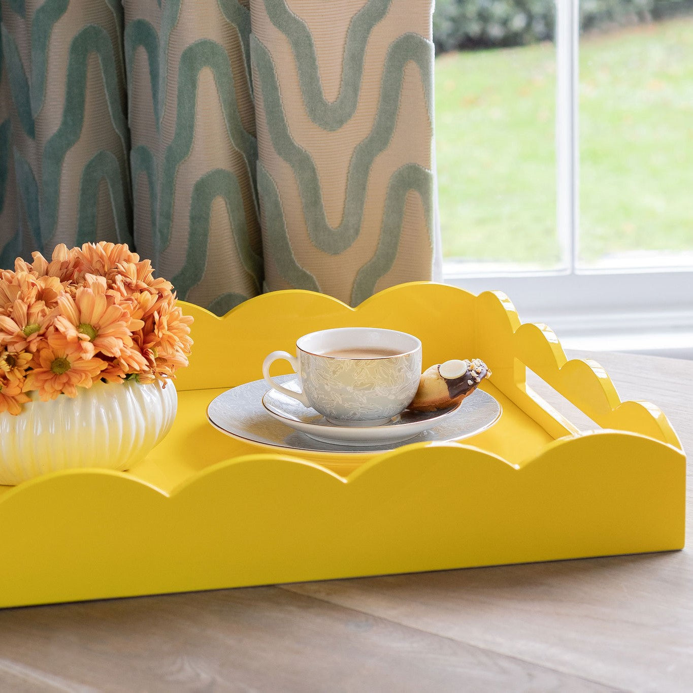 Coffee pots and cups on a yellow lacquer tray with a scalloped edge