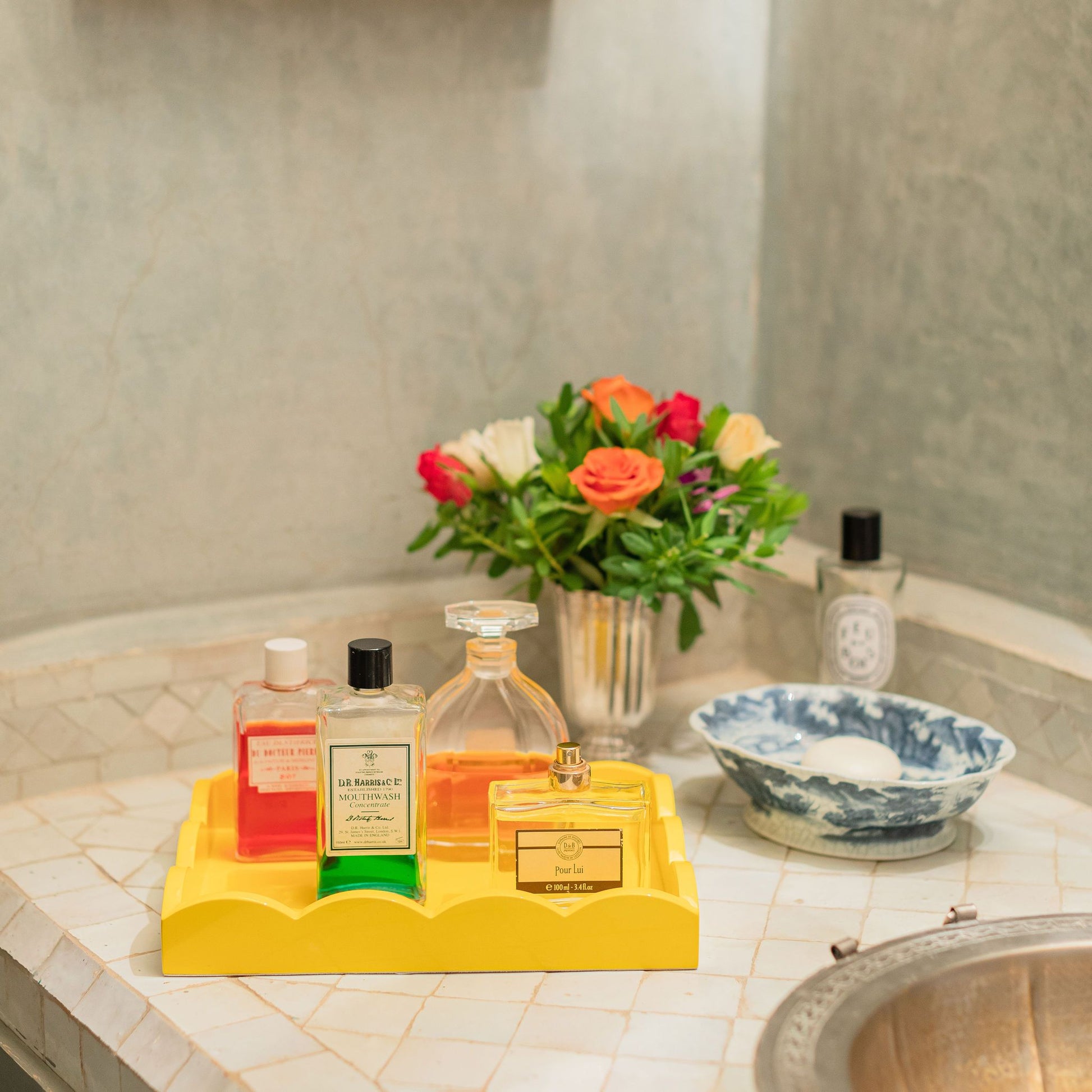 Perfume bottles on a small yellow lacquer tray with a scalloped edge