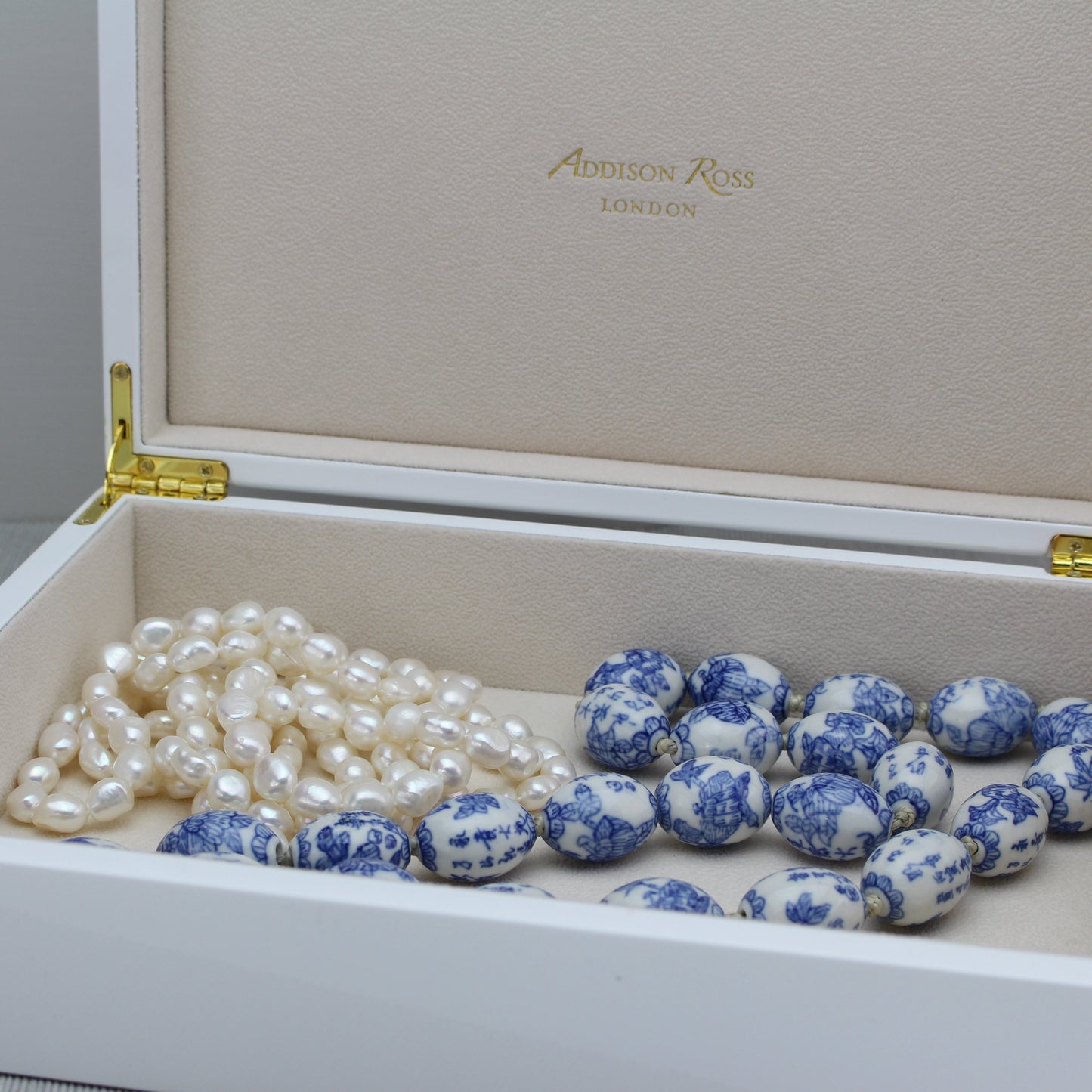 Two necklaces in a white storage box